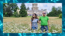 A couple walking through the blooming grounds at Studley Castle, a Warner Hotel. The boarder depicts the pool water in the hotels award-winning spa.